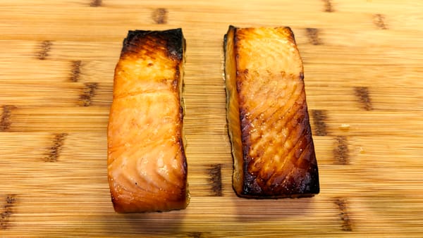 Miso glazed salmon fillets with caramelized edges on a wooden cutting board